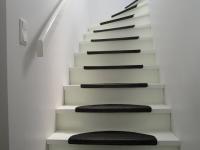 Treppe weiß mit schwarzen Anti-Rutsch-Matten
