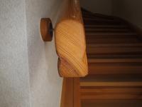 Nahaufnahme Geländer der gewendelten Holztreppe