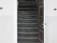 Alte Treppe schwarz hinter Innentür