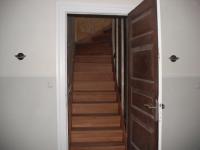 Dunkle Holztreppe hinter Innentür