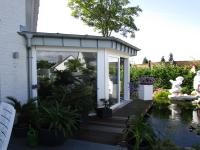 Außenansicht Fenster für Wintergarten mit weißem Rahmen an Teich 