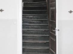 Alte Treppe schwarz hinter Innentür
