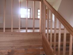 Holztreppe und Sicht ins obere Stockwerk