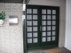Doppelflügelige Haustür in grün mit vielen Lichtausschnitten geschlossen
