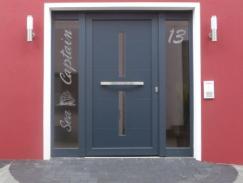 Haustür zu Apartment in blau mit zwei Lichtausschnitten und zwei Glas-Seitenteilen mit Schriftzug