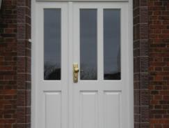 Haustür in weiß mit zwei Lichtausschnitten und Seitenteil mit Lichtausschnitt