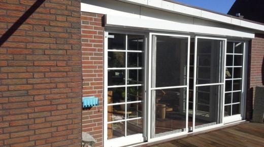 Doppelflügelige Terrassentür mit weißem Rahmen und Insektenschutz und zwei breiten Seitenteilen