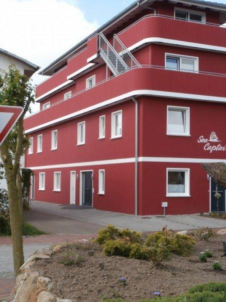 Hausansicht Apartment mit weißen Terrassentüren und Fenstern 