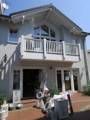 Hausansicht Fenster und Türen in weiß mit Geschäft im unteren Stockwerk