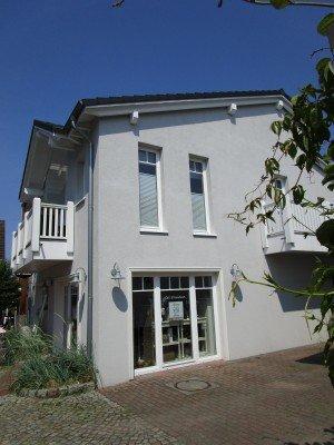 Hausansicht Fenster weiß mit Geschäft im unteren Stockwerk