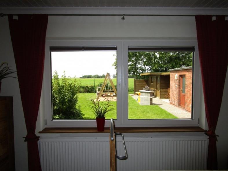 Innenansicht Fenster weiß mit Holzfensterbank und abdunkelnden Plissees