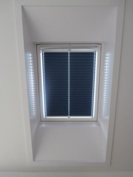 Plissee mit einem abdunkelnden blauen Stoff