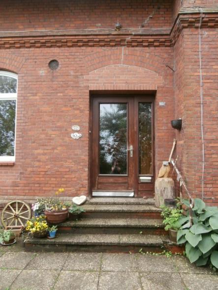 Alte Haustür in braun mit großem Lichtausschnitt und Seitenteil und Briefkasten