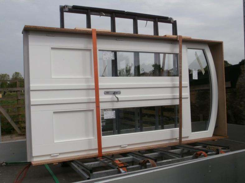 Transport der doppelflügeligen weißen Haustür mit drei Lichtausschnitten und Rundbogen