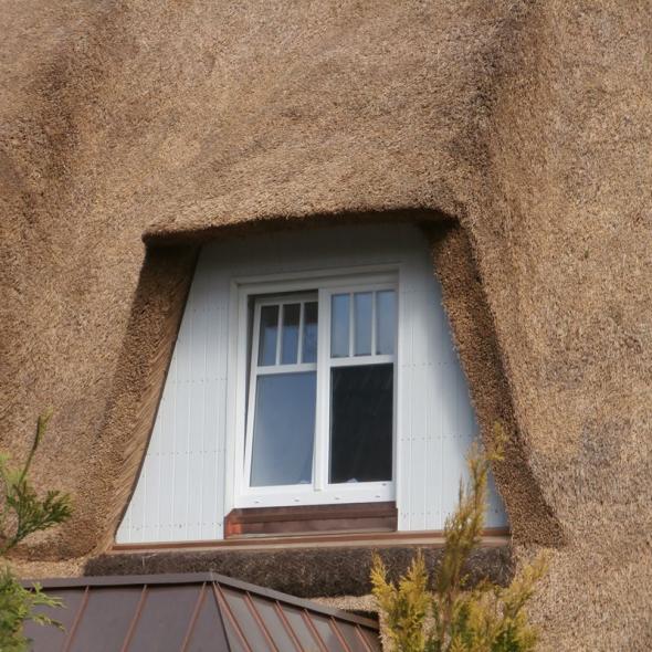 Außenansicht Holzfenster bei Reetdach-Haus