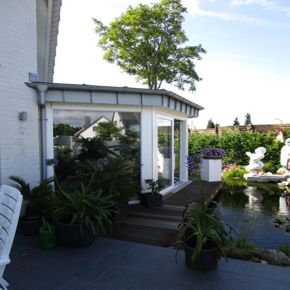 Außenansicht Fenster für Wintergarten mit weißem Rahmen an Teich