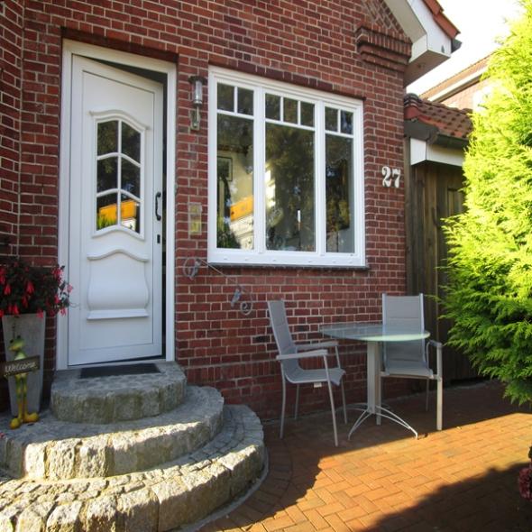 Haustür mit Lichtausschnitten und drei Fenster in weiß