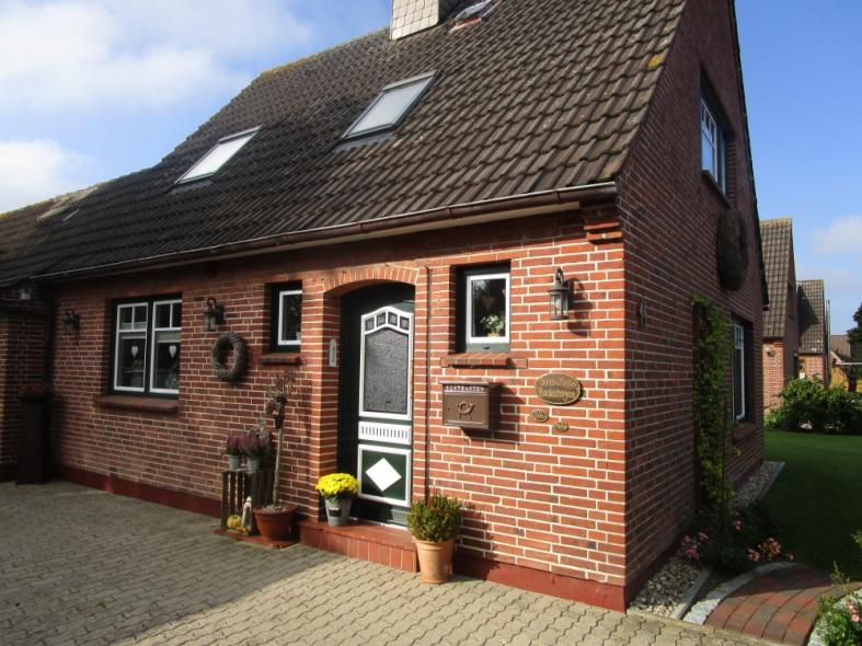 Hausansicht mit mit grün-weißer Haustür und Lichtausschnitt