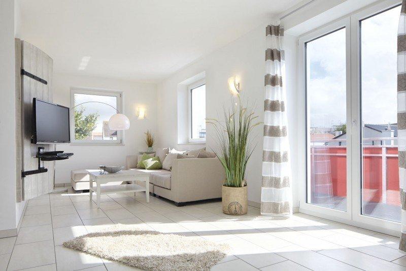 Innenansicht Apartment mit weißen Terrassentüren und Fenstern