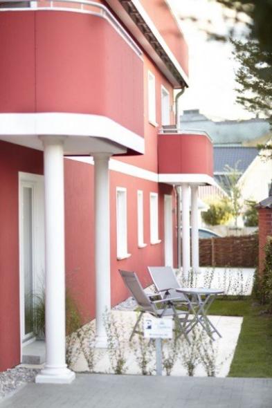 Terrasse von Apartment mit weißen Terrassentüren und Fenstern