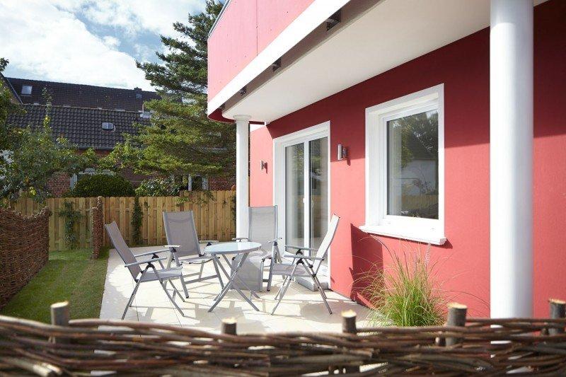 Terrasse von Apartment mit weißen Terrassentüren und Fenstern 