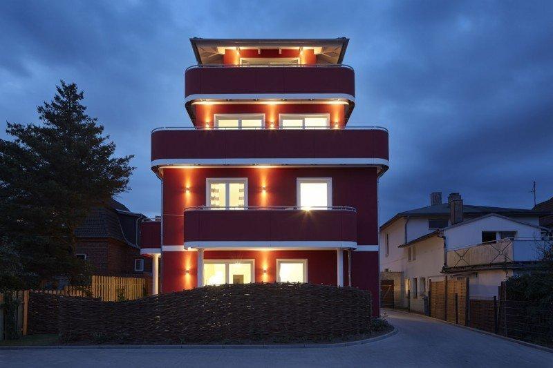 Hausansicht Apartment mit weißen Terrassentüren und Fenstern Beleuchtet