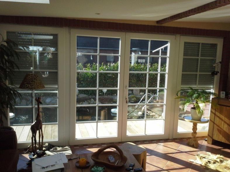 Innenansicht Terrassentür mit weißem Rahmen und Insektenschutz und zwei breiten Seitenteilen