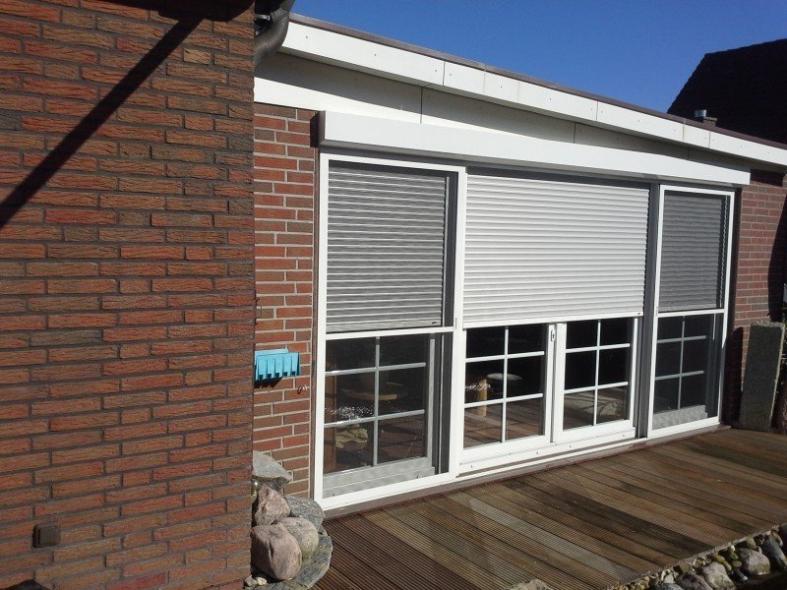 Terrassentür mit weißem Rahmen und Insektenschutz und zwei breiten Seitenteilen mit Rollläden