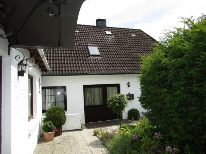 Hausansicht Haustür braun mit Lichtausschnitt mit Vorhang und breitem Seitenteil mit Lichtausschnitt und Vorhang