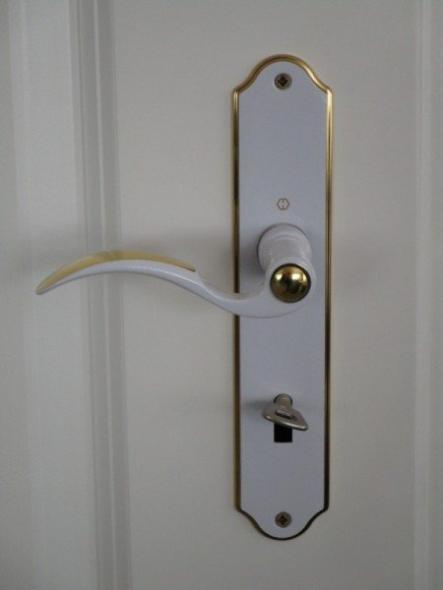 Nahansicht Türgriff in weiß mit goldenen Elementen