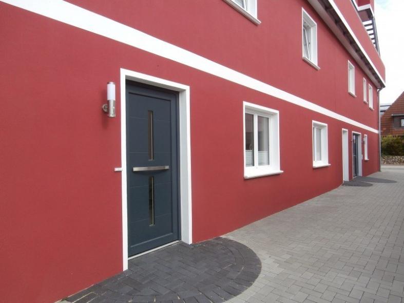 Nahaufnahme Hausansicht Apartment mit weißen Terrassentüren und Fenstern