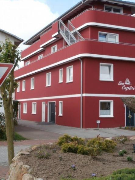 Hausansicht Apartment mit weißen Terrassentüren und Fenstern