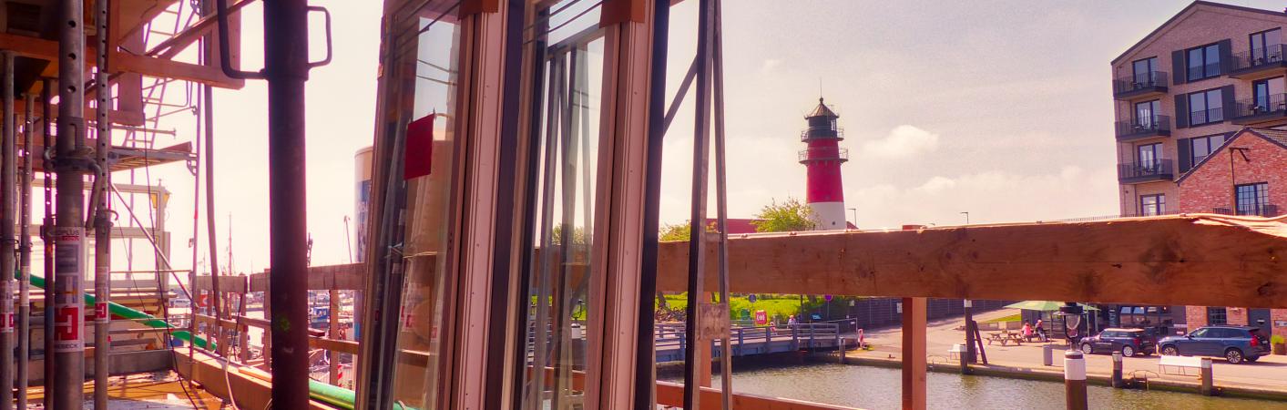 Blick über eine Baustelle auf den Leuchtturm Büsum